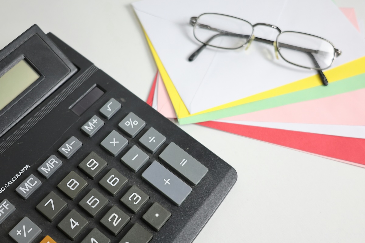 A calculator and a pair of glasses laid on a desk